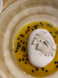 Elegant Porcelain Bowl with Yellow Liquid and Coconut Topping