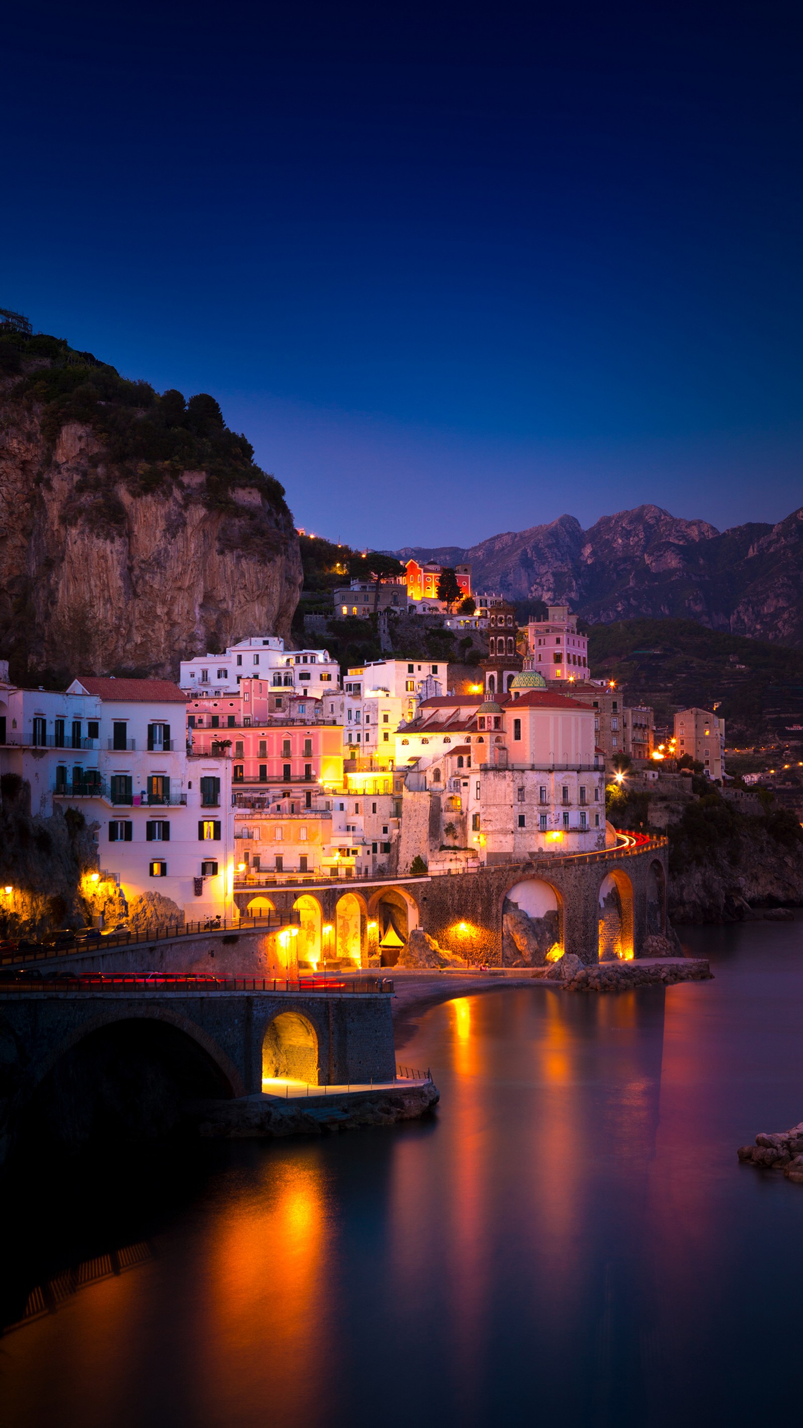 Vista aérea de uma cidade em uma colina com uma ponte sobre a água. (costa amalfitana, positano, sorrento, capri, guia)