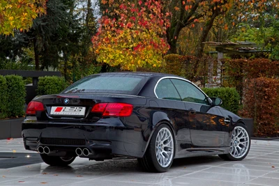 Elegante BMW Série 3 E90 Conversível com rodas de liga leve em um cenário outonal pitoresco.