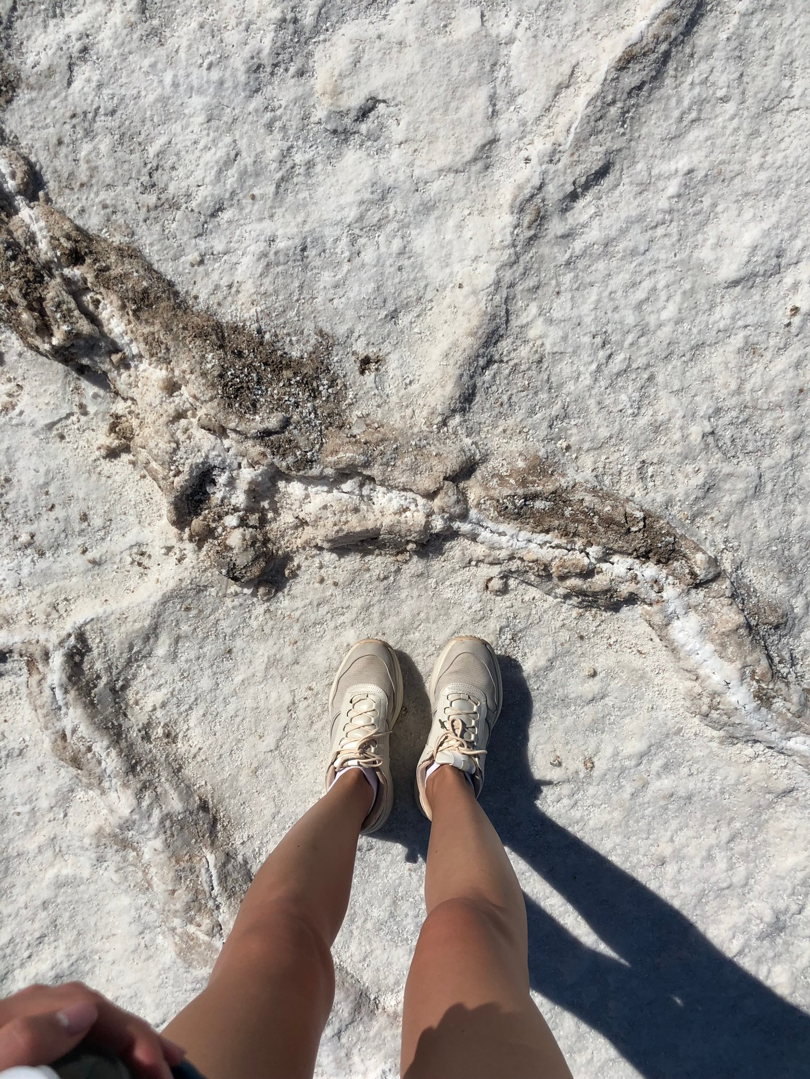 Alguien de pie sobre una roca con los pies en el aire (ee uu, usa, nevada, valle de la muerte, parque nacional de la valle de la muerte)