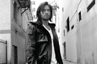 Hugh Jackman as Wolverine in a stylish black leather jacket, captured in a monochrome street scene.