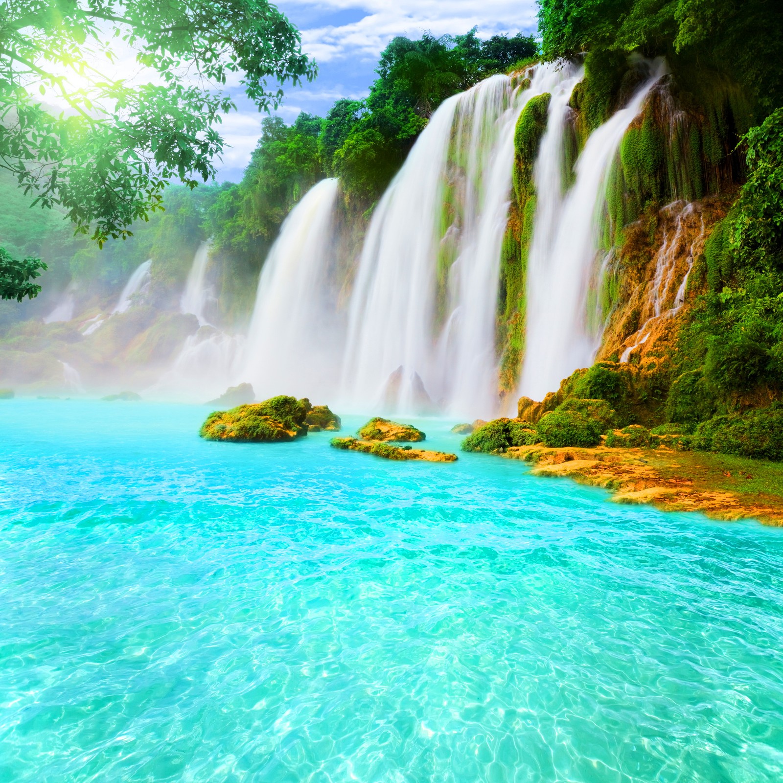 Una gran cascada con agua azul y árboles verdes (hermoso, naturaleza, tropical, cascada)