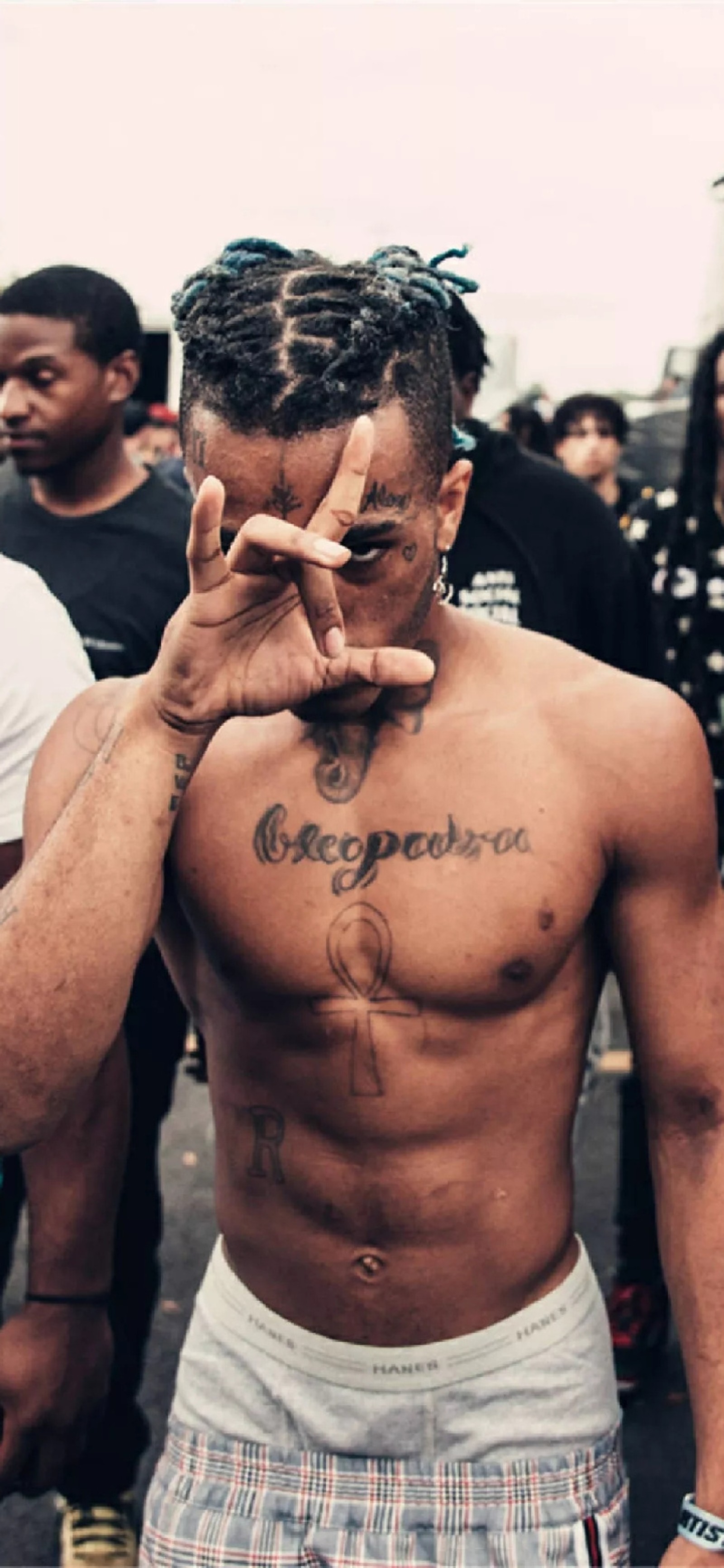 Un hombre con un tatuaje en el pecho haciendo un signo de paz (fondo de pantalla)