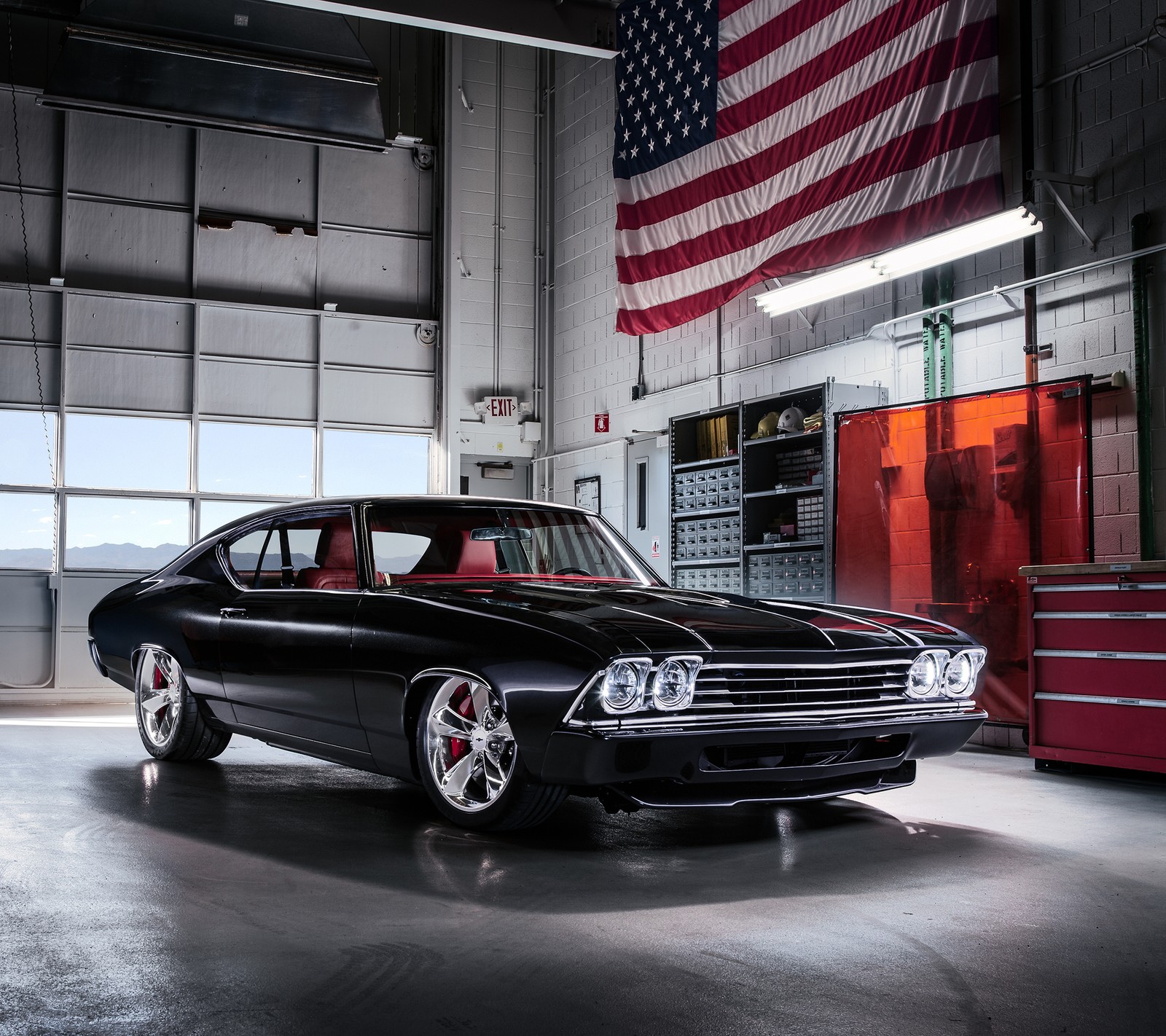 A close up of a car in a garage with an american flag (black, car, classic, garage, retro)