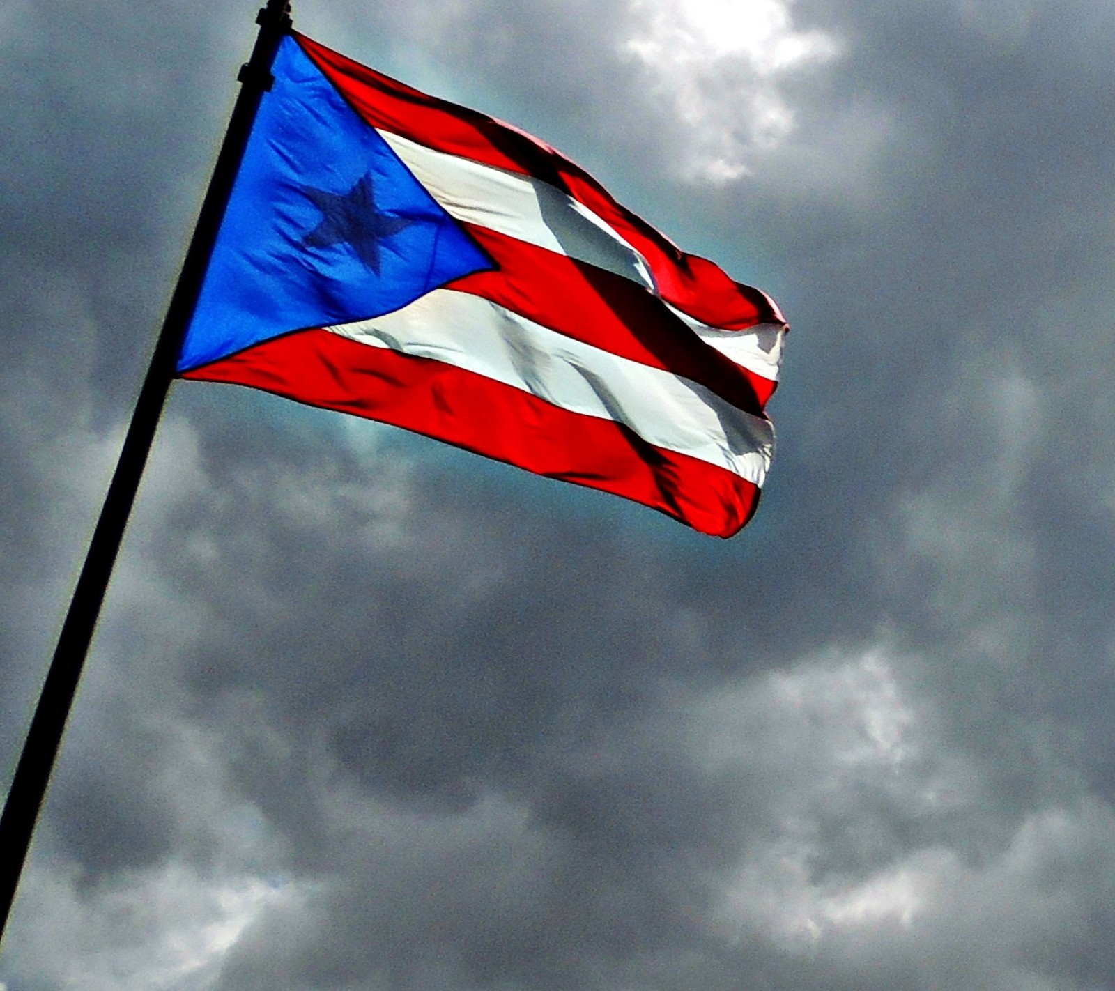 Céu nublado com uma bandeira de porto tremulando ao vento (porto rico, puerto rico, puerto rico flag)