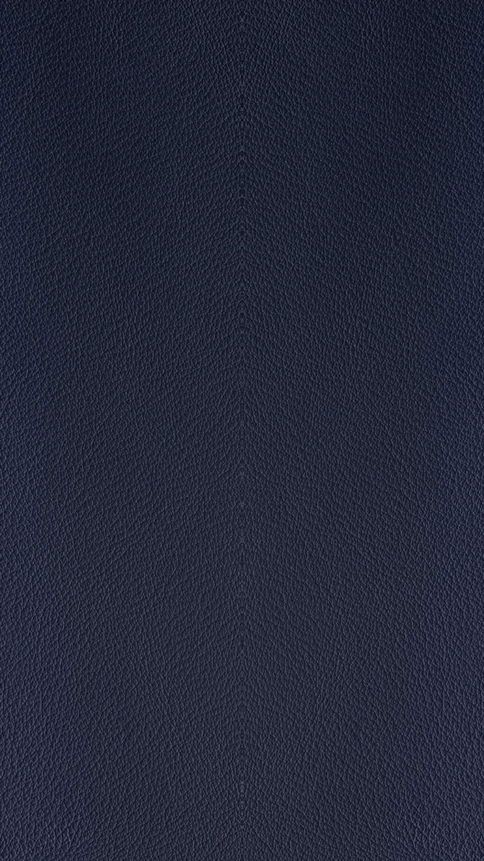 A close up of a blue leather surface with a black background (leather, midnight blue)