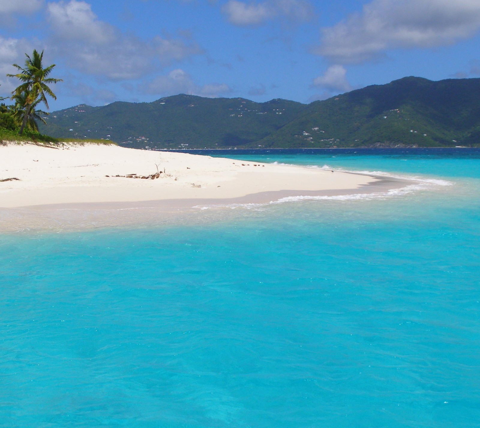 Eau turquoise et plage de sable blanc avec des palmiers et des montagnes en arrière-plan (plage, sable)