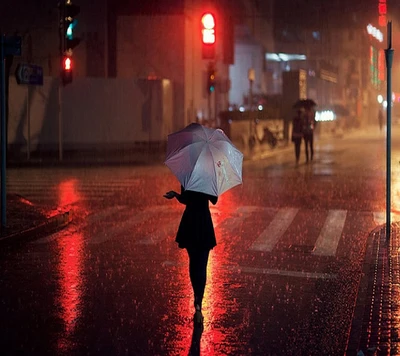 Figura solitária com guarda-chuva na rua molhada pela chuva