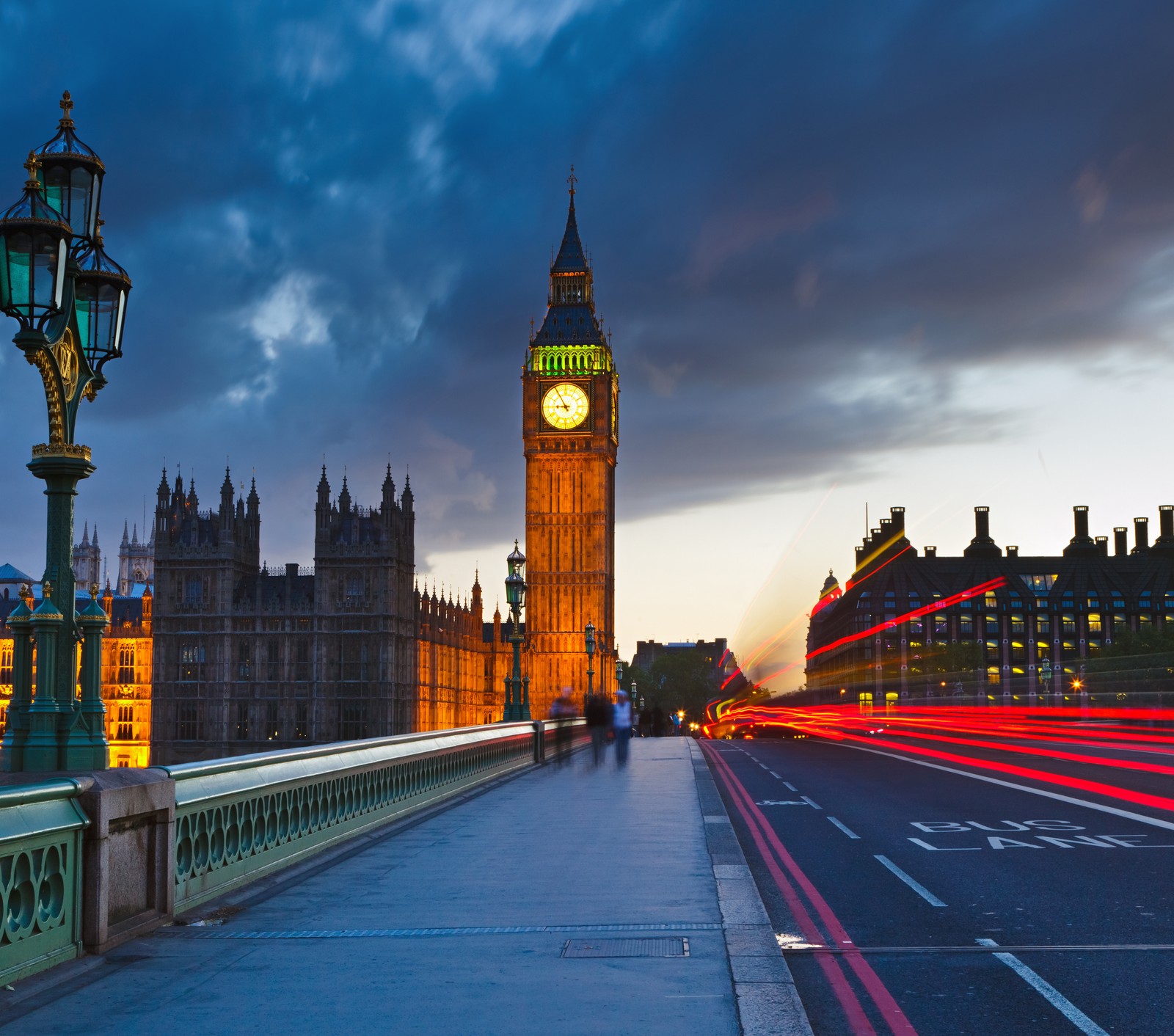 Una vista mimada de una torre del reloj con una farola en primer plano (londonl, oi)