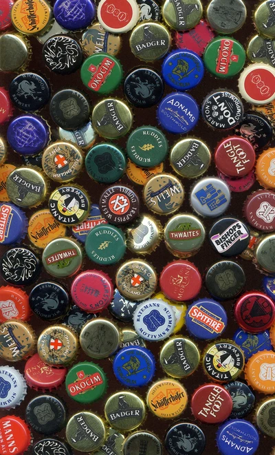 Une collection vibrante de capsules de bouteilles de bière colorées présentant divers logos et designs de brasseries.