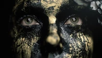 Intense Close-Up of a Face with Black and Gold Paint, Evoking Mystery in Death Stranding 2