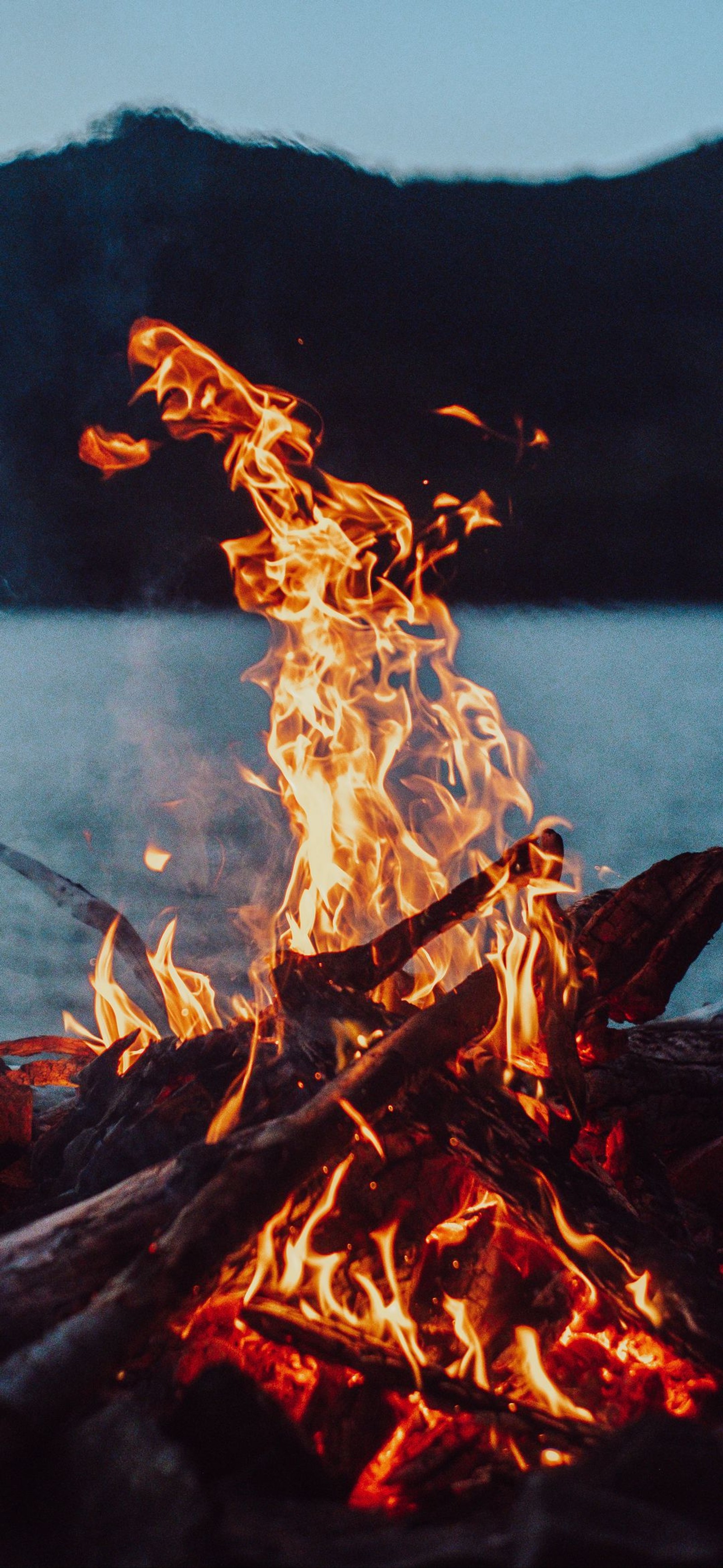 There is a fire that is burning in the middle of the night (bonfire, fire, flame, table, light)