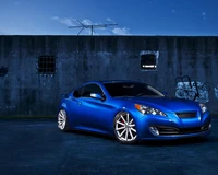 Hyundai Genesis Coupe bleu élégant avec des jantes sportives contre un arrière-plan urbain