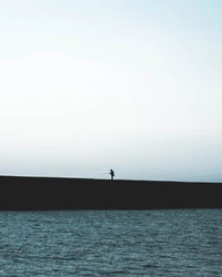 Solitary Fisherman by the Calm Horizon