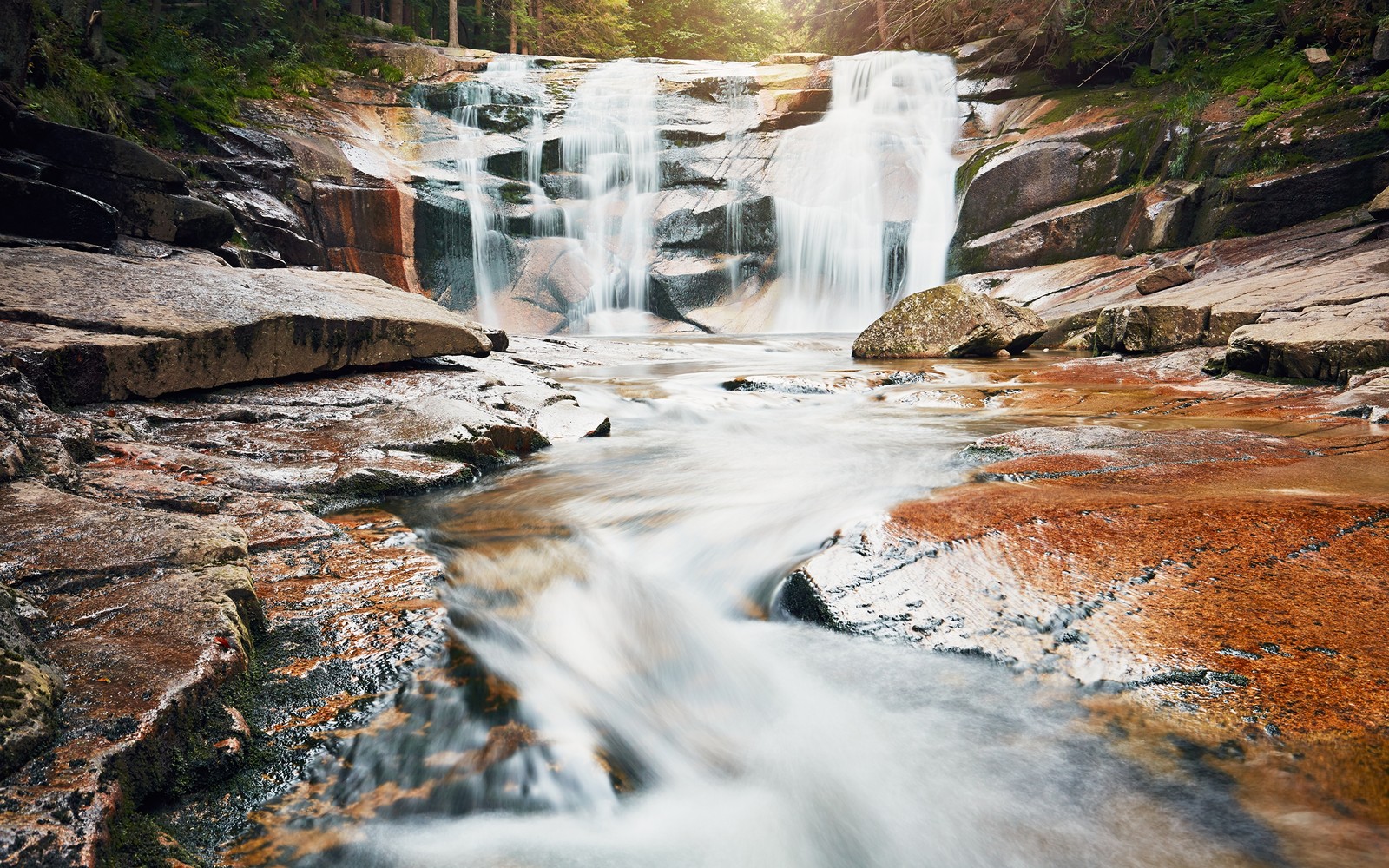 Un gros plan d'une cascade avec une forêt en arrière-plan (la cascade, plan deau, ressources en eau, nature, eau)