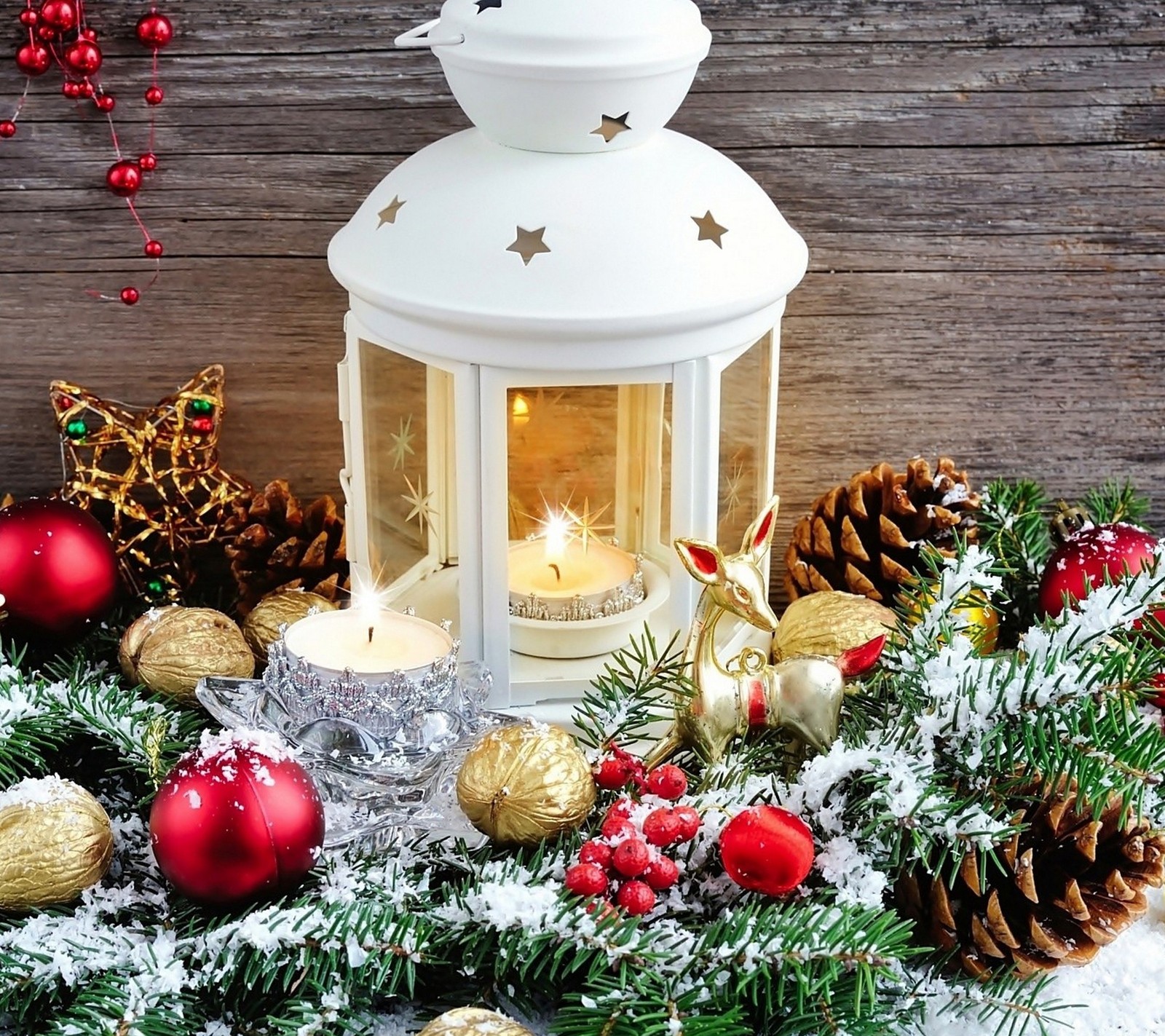 Il y a une lanterne blanche avec une bougie à l'intérieur entourée de décorations de noël (noël, décoration de noël, lampe, joyeux, neige)