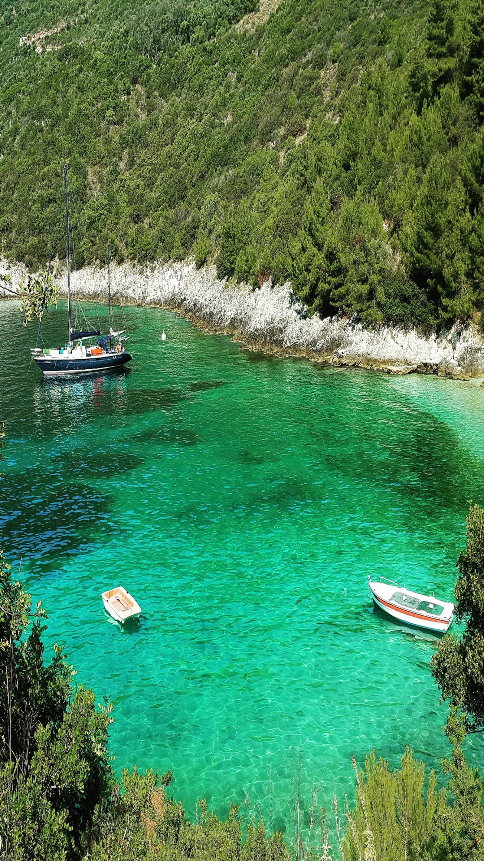 Barcos estão ancorados nas águas azuis claras de uma baía (2015, afteli, praia, verde, lefkada)