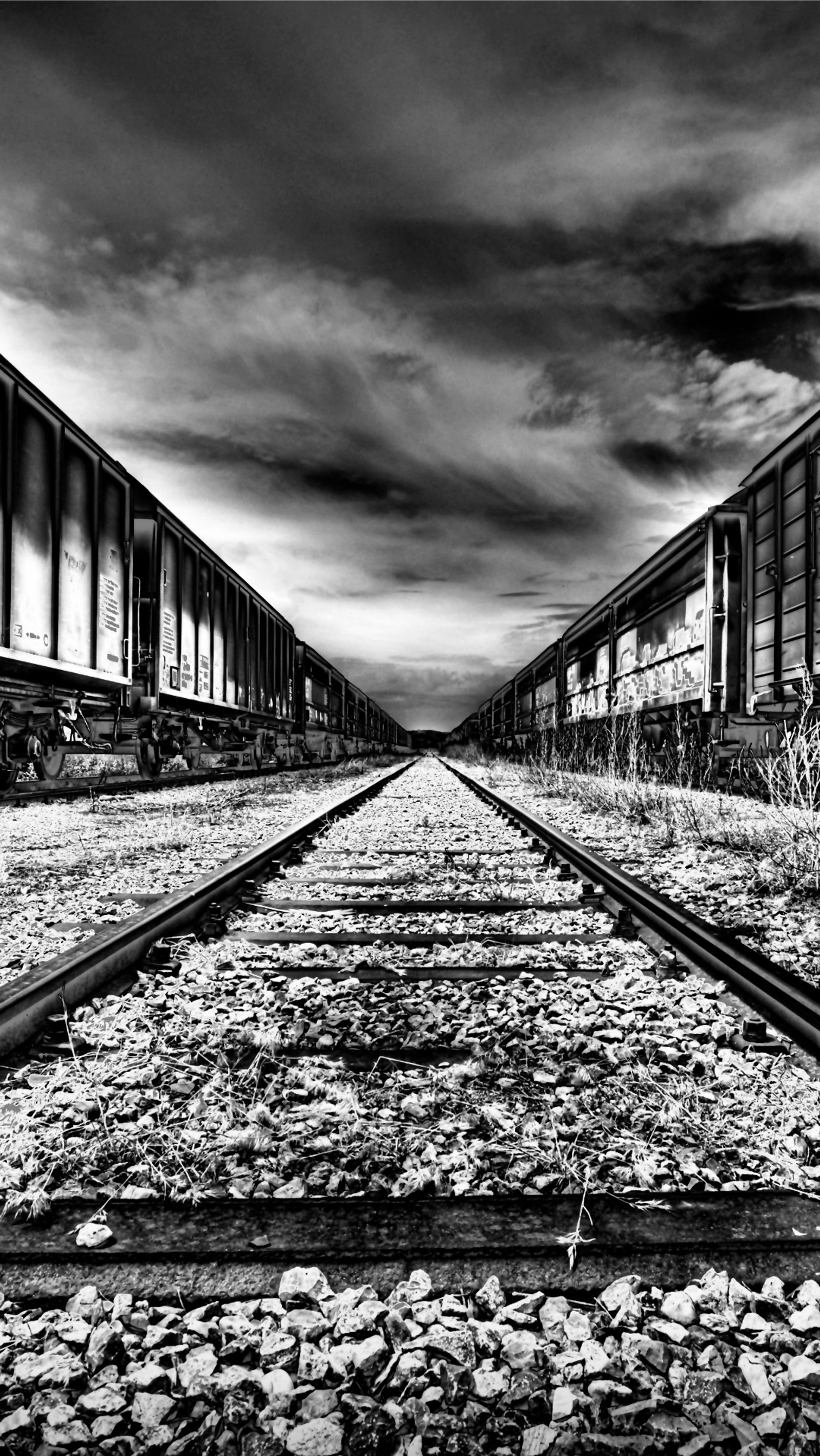 Verrostete bahngleise mit einem waggon, der auf den gleisen steht (verlassen, dunkel, landschaft, tracks)