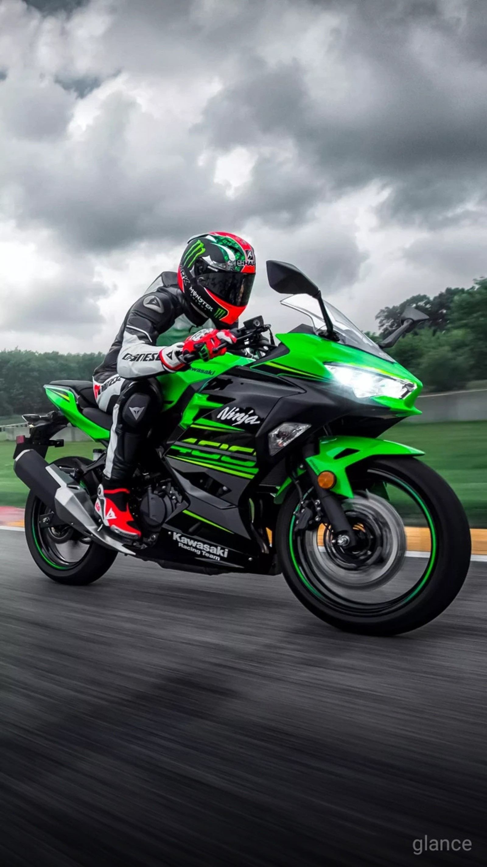 Arafed man riding a green motorcycle on a race track (motor, motorcycle, premium)