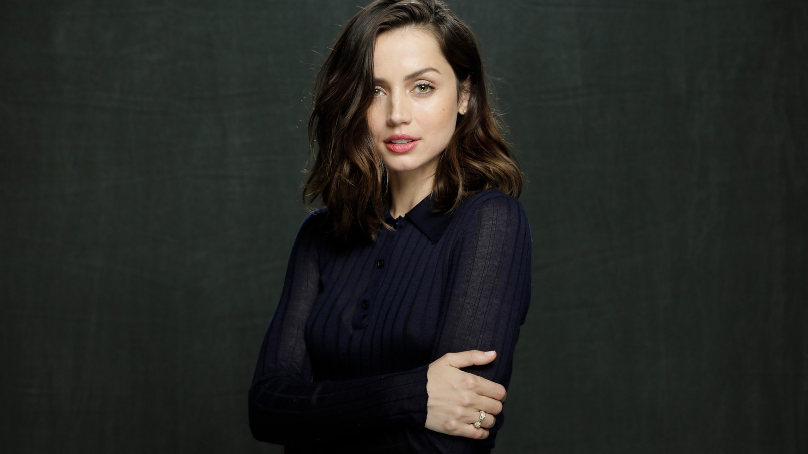 A woman with a black shirt and a black shirt posing for a picture (face, neck, sleeve, gesture, grey)