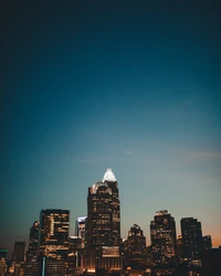 Städtische Skyline bei Dämmerung mit hohen Wolkenkratzern und klarem blauen Himmel