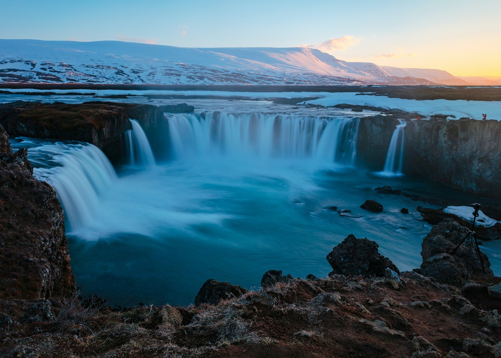 Uma cachoeira na islândia com um pôr do sol ao fundo (cachoeira, água, recursos hídricos, paisagem natural, nuvem)