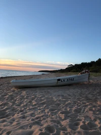 Linha costeira tranquila ao pôr do sol com barco abandonado