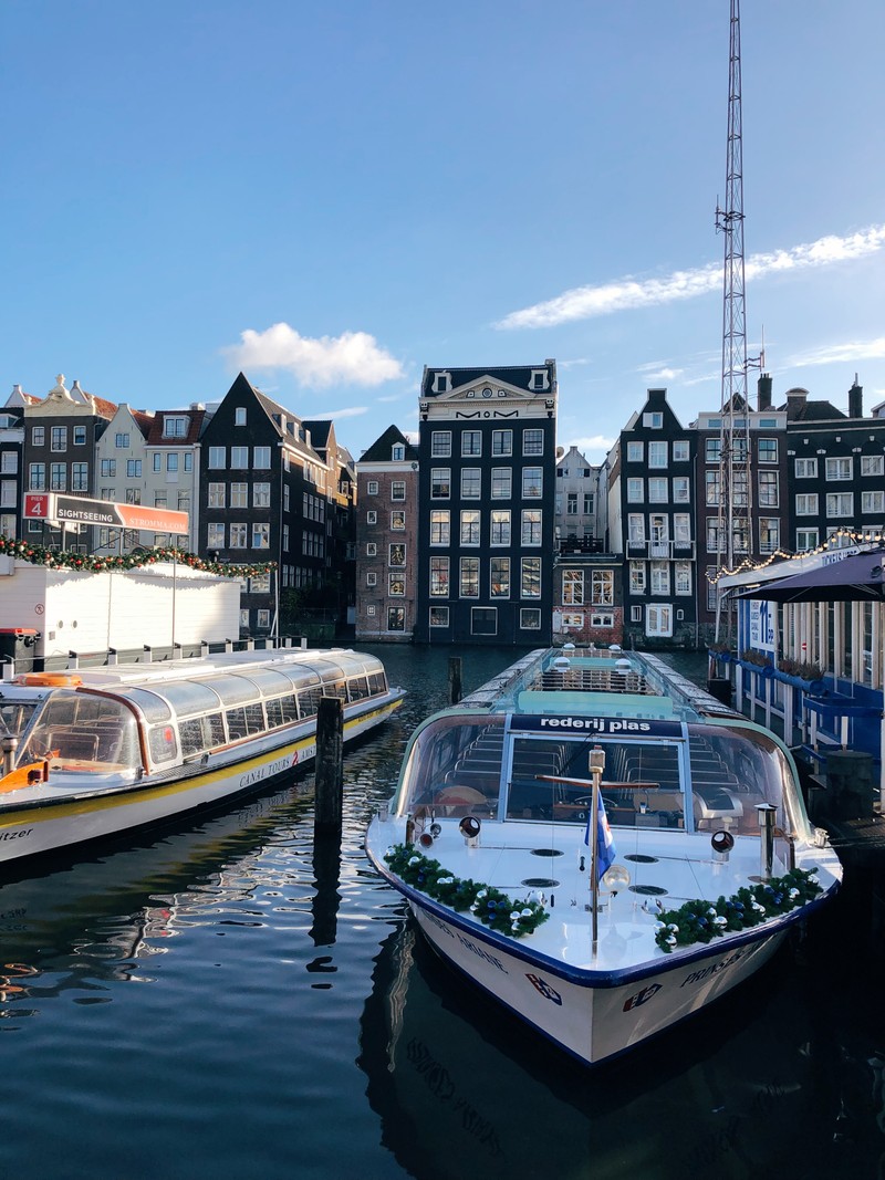 Лодки пришвартованы в гавани на фоне зданий (амстердам, amsterdam, вода, водоем, водный путь)