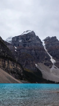 Lac Moraine : Un paysage de haute montagne serein entouré de montagnes majestueuses et d'eaux glaciaires