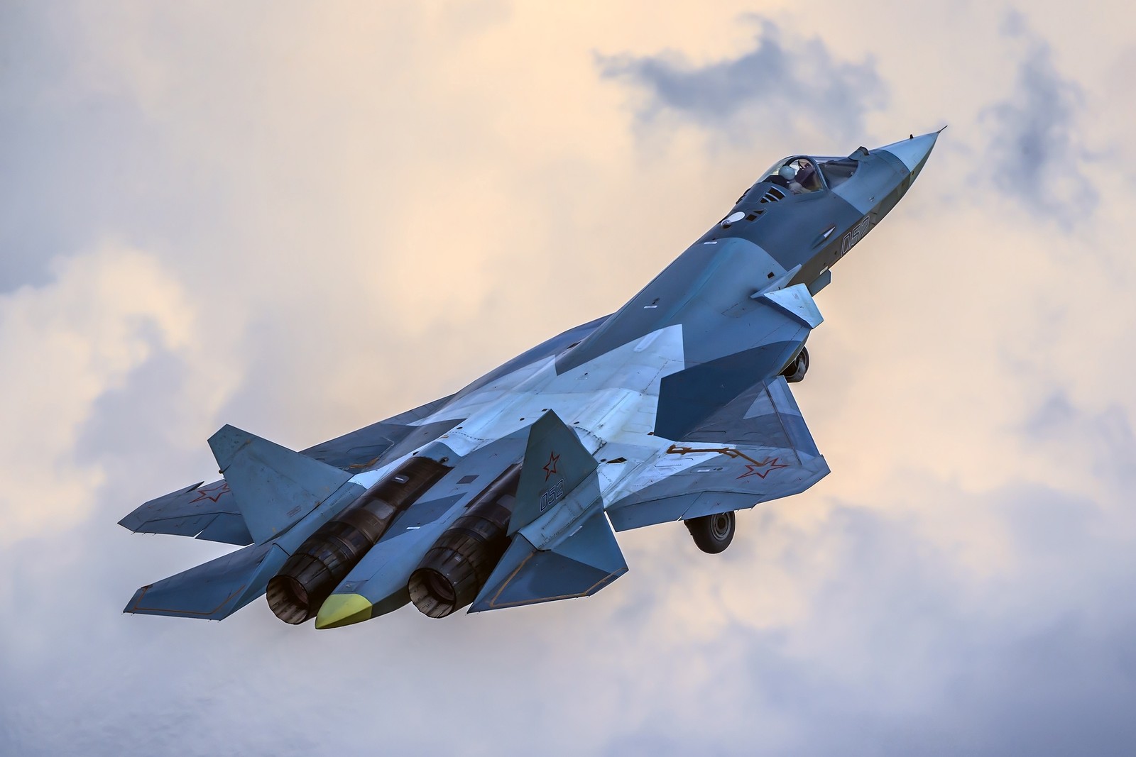 There is a fighter jet flying through the air with a cloudy sky behind it (sukhoi su 57, military aircraft, aircraft, airplane, air force)