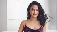 Camila Mendes in a stylish purple satin top, exuding confidence and charm.