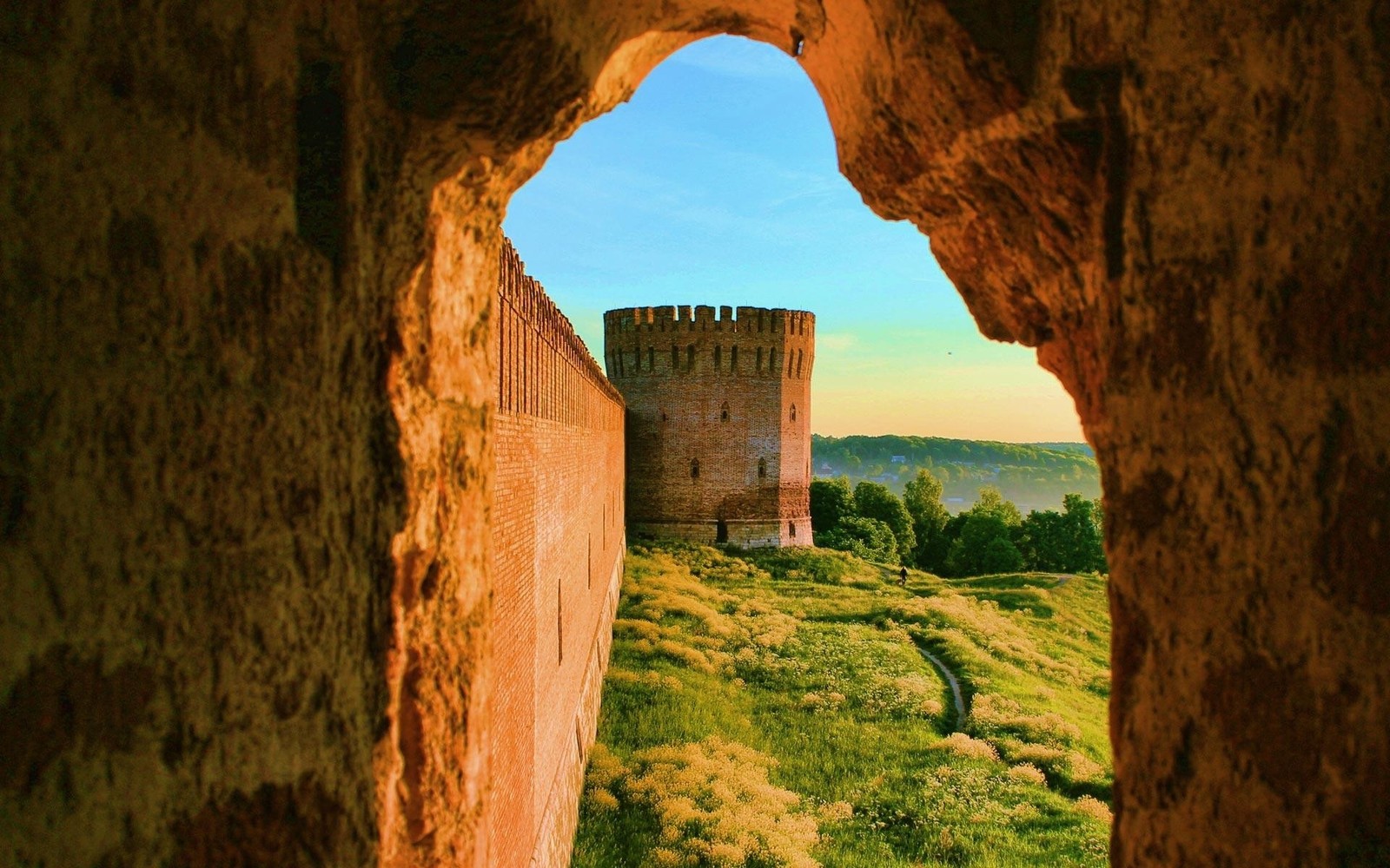 Eine sicht auf ein schloss durch ein loch in einer felsenwand (ruinen, bogen, fels, historische stätte, alte geschichte)