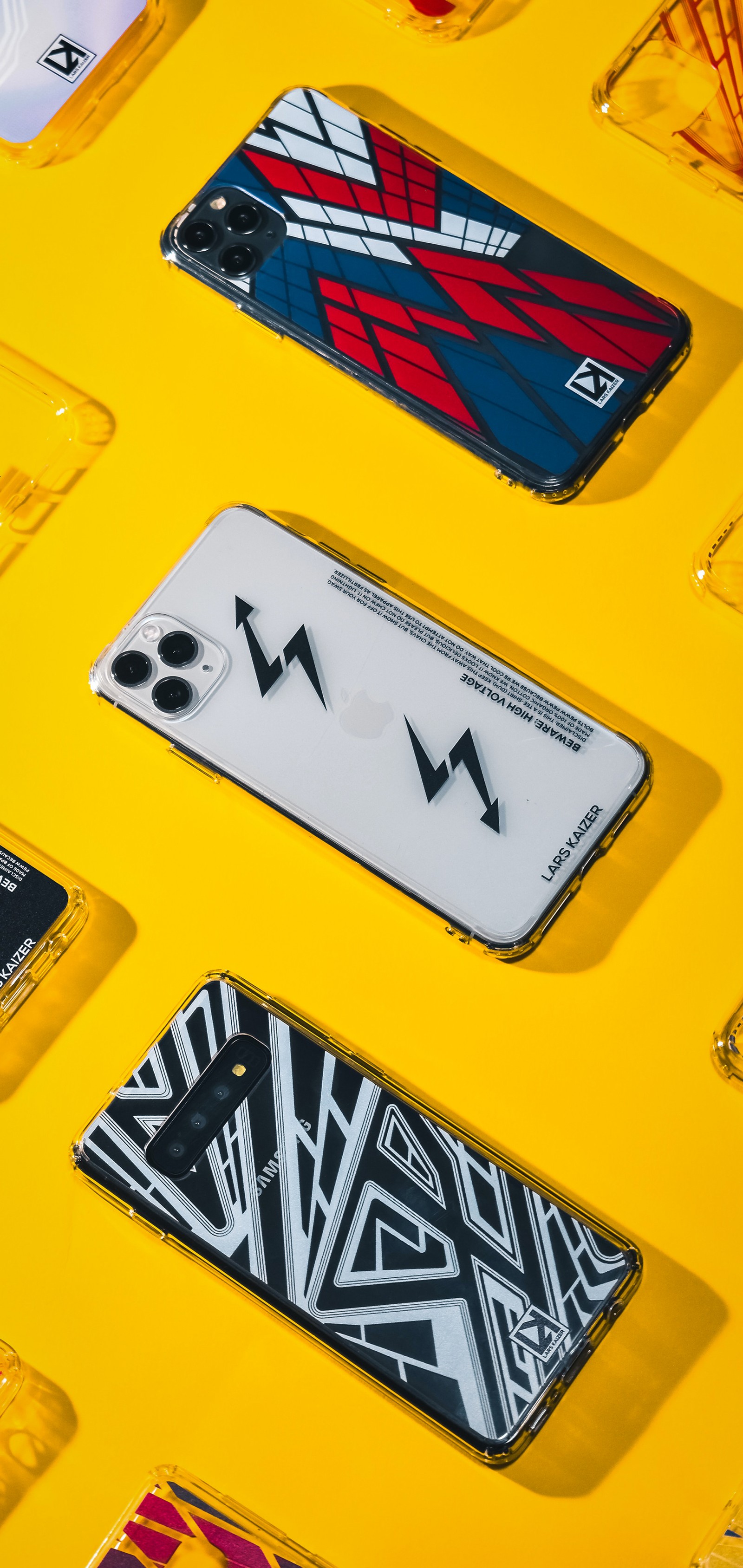 Several different cases are arranged on a yellow surface (smartphone, telephone, yellow, triangle, rectangle)