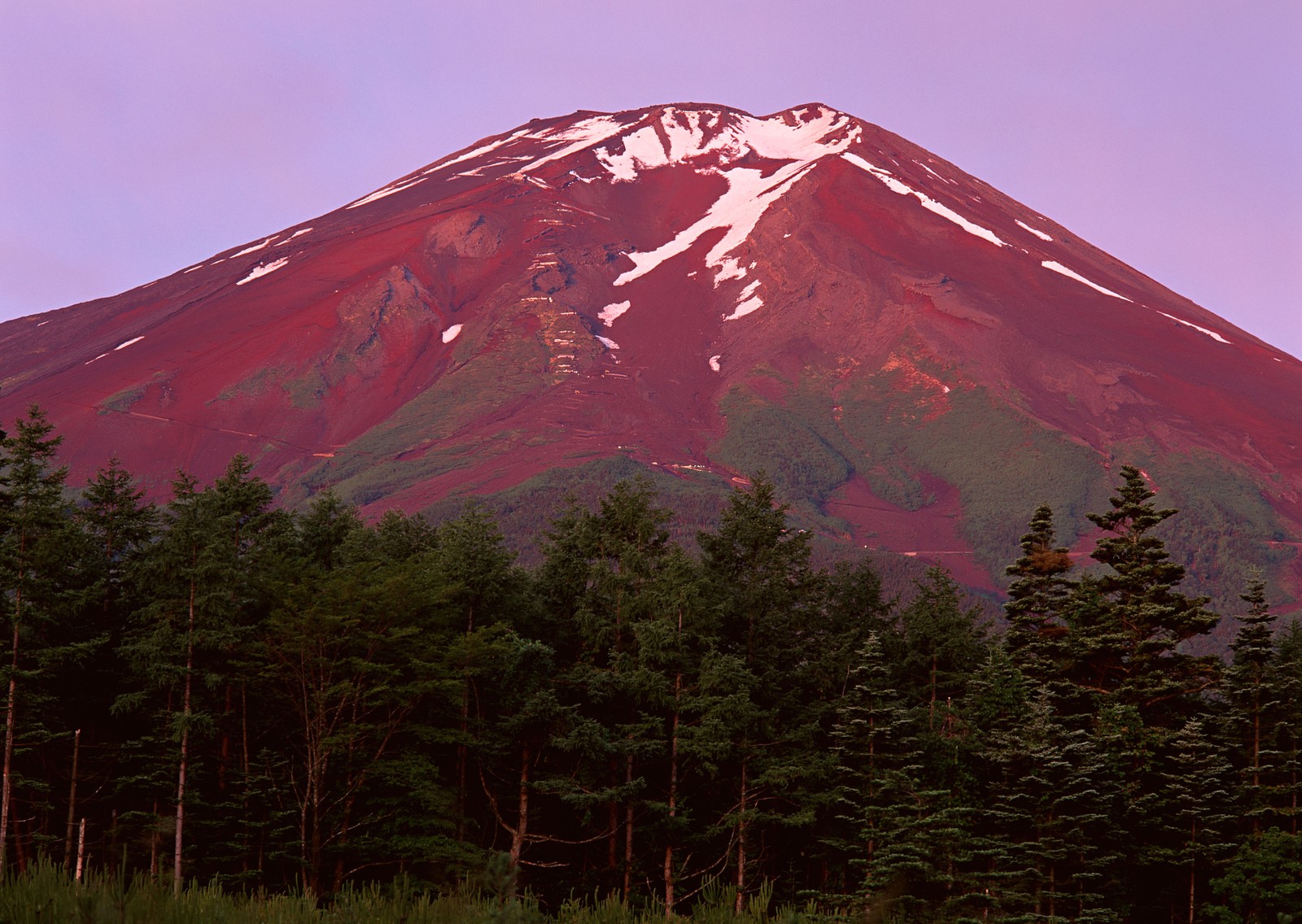 Une montagne avec un sommet rouge et des arbres au premier plan (mont fuji, volcan, décor montagnard, formes montagneuses, montagne)