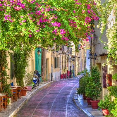 Encantadora calle de verano en Grecia rodeada de exuberante bugambilia