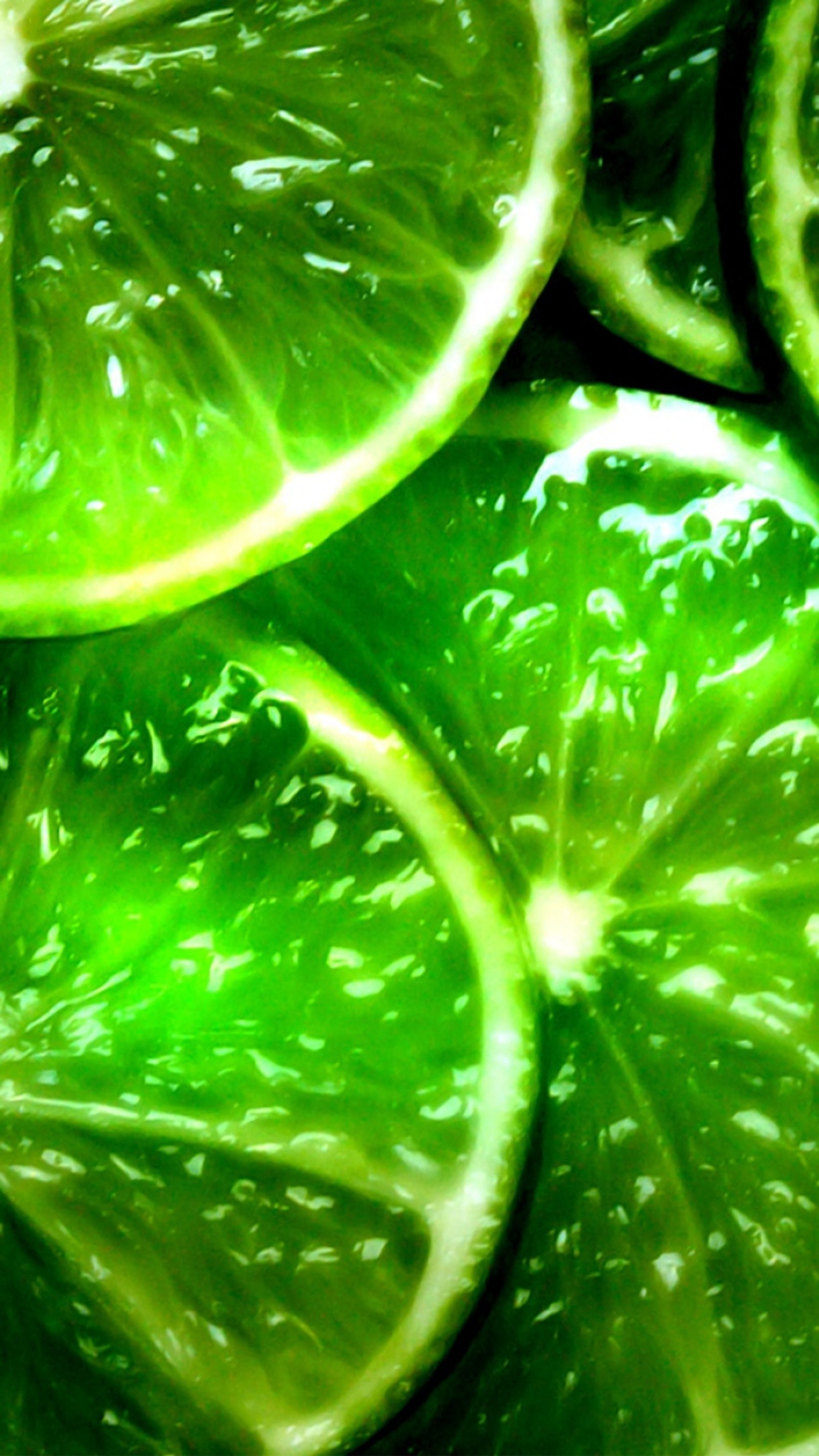 A close up of a bunch of limes cut in half (bright, green, limes)