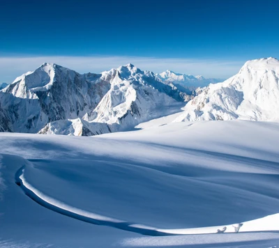 Montanhas majestosas cobertas de neve sob um céu de inverno claro