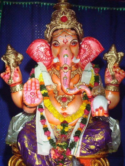 Idol of Lord Ganesha adorned with flowers and jewelry, symbolizing prosperity and wisdom.