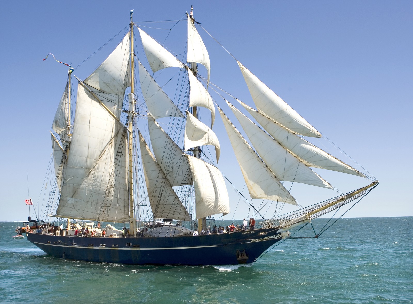 Un voilier avec des voiles blanches dans l'océan ouvert (barquentine, voile, voilier, mât, bateau)