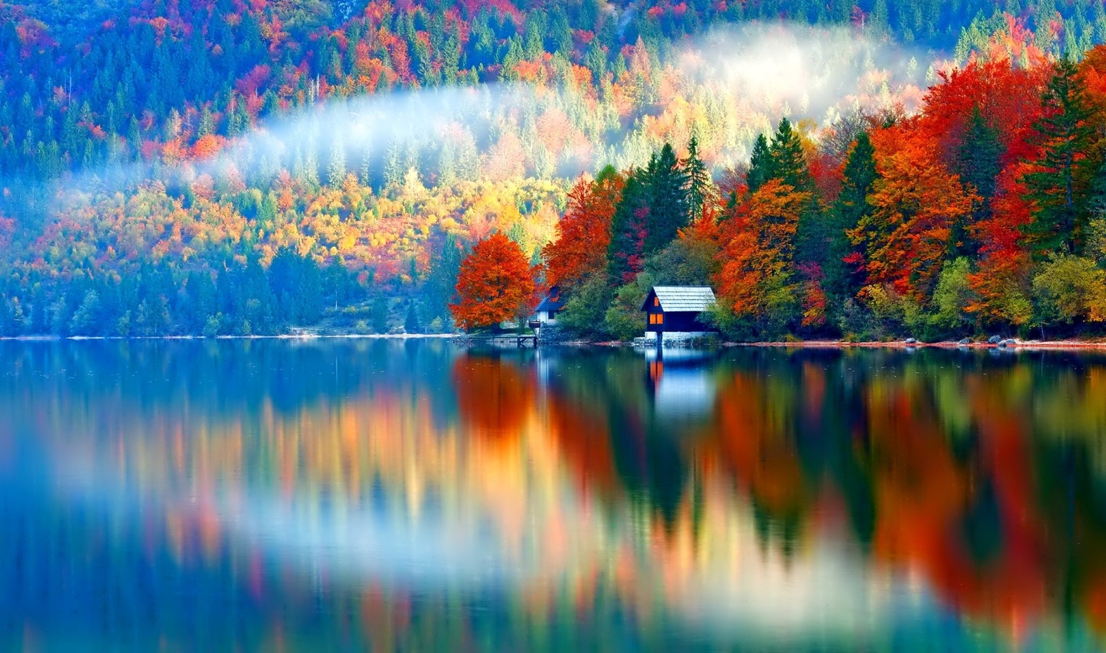 Una vista de un lago con una casa de botes en el medio (reflexión, naturaleza, hoja, árbol, agua)