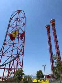 Roda-gigante e maravilha da engenharia em vermelho contra um céu limpo