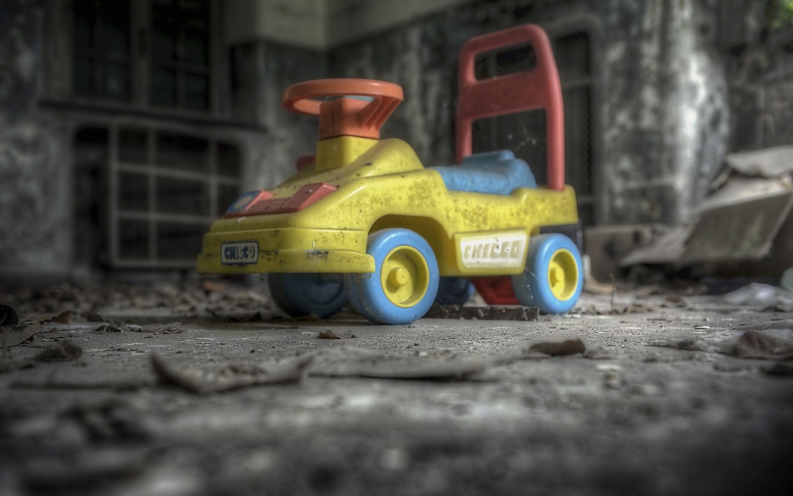 There is a toy car that is sitting in the dirt (yellow, machine, mode of transport, motor vehicle)