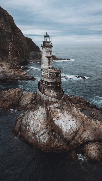 Majestoso farol de pé sobre rochas costeiras acidentadas