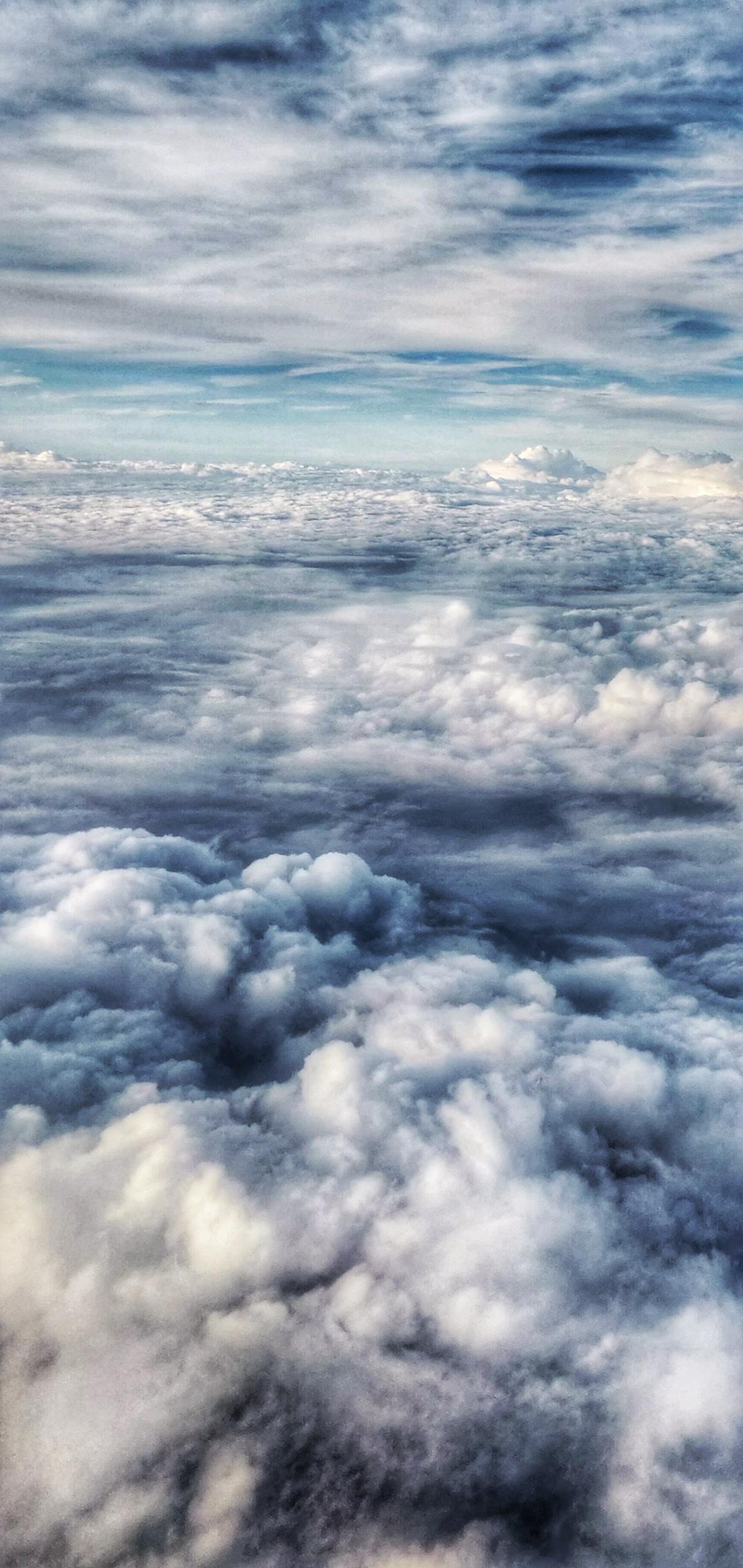 Una vista aérea de un avión volando sobre las nubes en el cielo (nube, atmósfera, cúmulo, paisaje, horizonte)