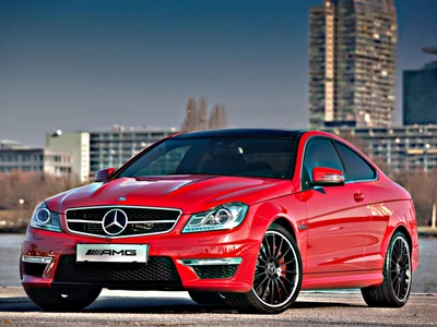 Mercedes Benz C 63 AMG Coupé rojo con llantas elegantes contra un fondo urbano.