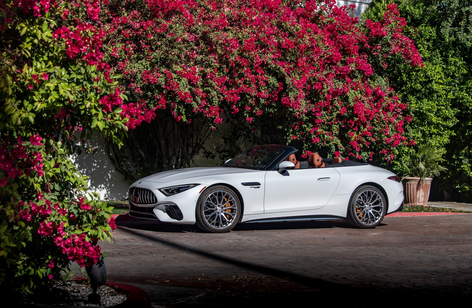 Un homme conduisant une voiture de sport blanche dans une rue à côté d'un arbre (mercedes amg sl 55 4matic, 5k, 2022, voitures, fond décran 4k)