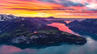 Impresionante vista aérea de Fronalpstock al anochecer: cielo naranja sobre la cordillera suiza