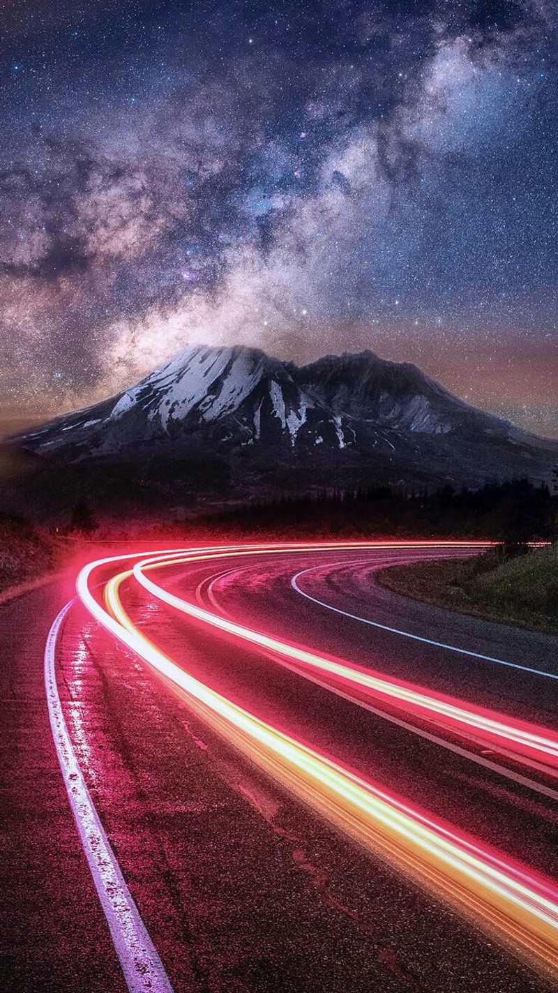 Vue aérienne d'une montagne avec une route et une traînée lumineuse d'une voiture (phares de voiture, rapide, montagne, nature, nuit)