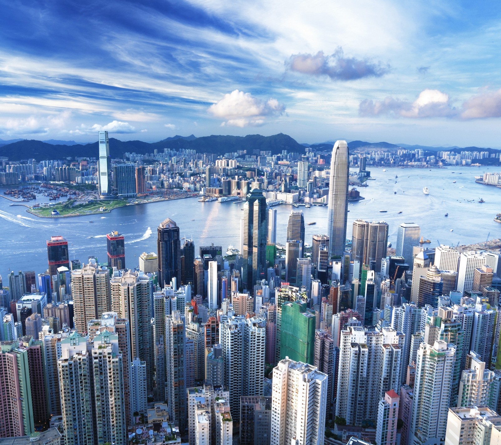 Una toma del horizonte de la ciudad con un río y un barco en el agua (hermoso, edificios, ciudad, hd, hong kong)