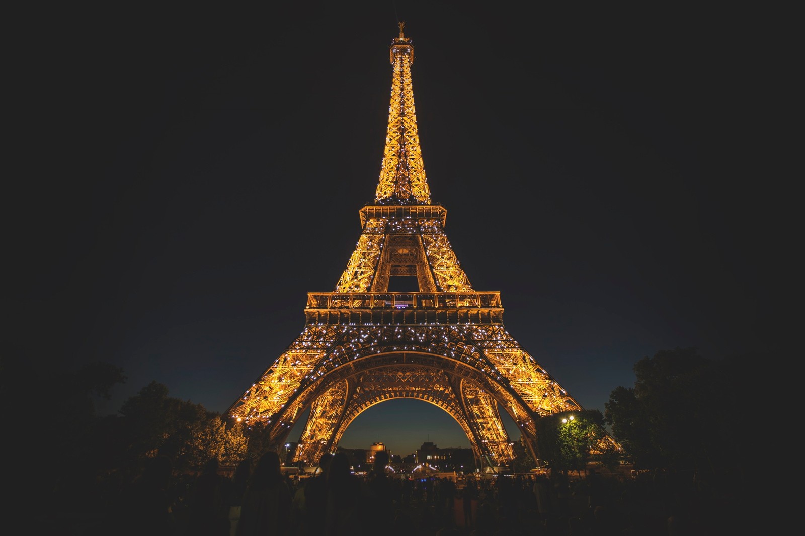 Um close em uma torre muito alta iluminada à noite (frança, magia, noite, paris, torre)